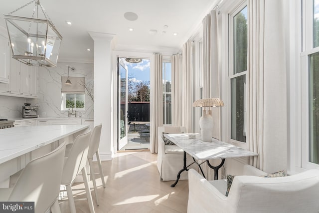 kitchen featuring white cabinets, decorative backsplash, ornamental molding, light stone countertops, and recessed lighting