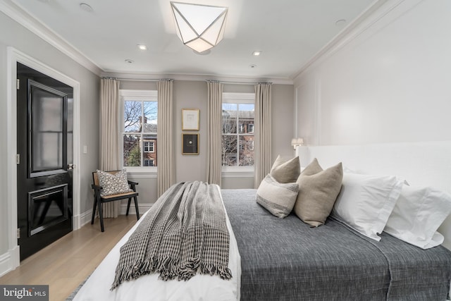 bedroom with crown molding, baseboards, and wood finished floors