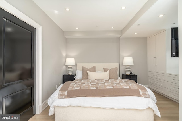 bedroom with light wood-type flooring, baseboards, and recessed lighting