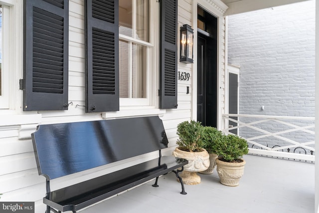 property entrance with brick siding and a porch