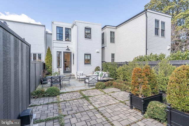 back of property with a patio area, brick siding, and a fenced backyard