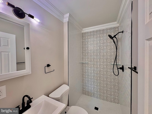 bathroom featuring a shower stall, a sink, toilet, and crown molding