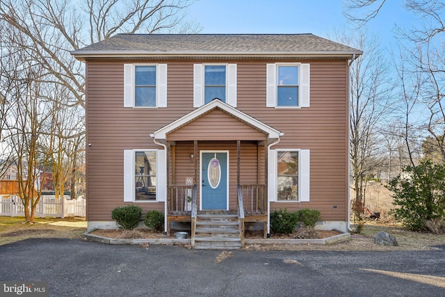 view of front of house featuring a shingled roof and fence