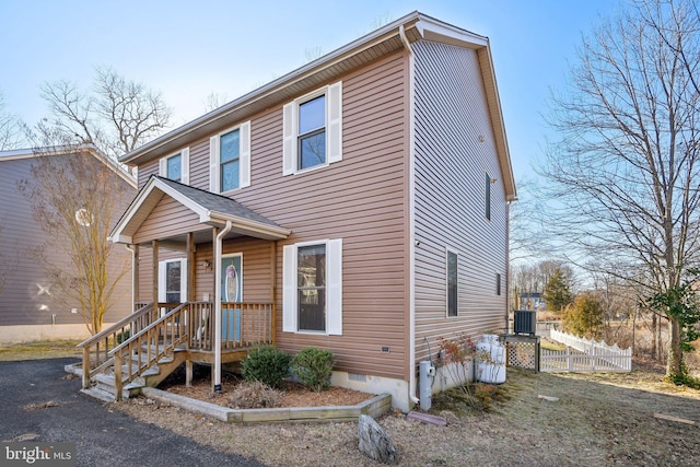 view of front of home with crawl space, central AC, and fence