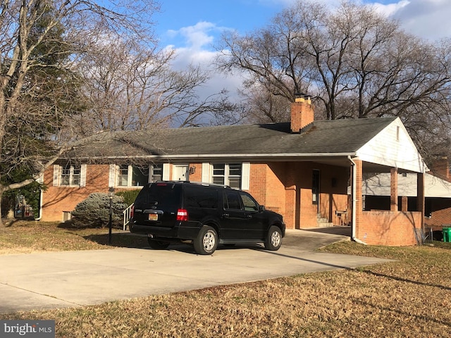 ranch-style house with driveway, brick siding, a chimney, and roof with shingles