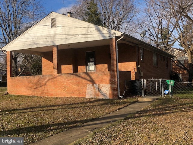 view of home's exterior with a yard, brick siding, and fence