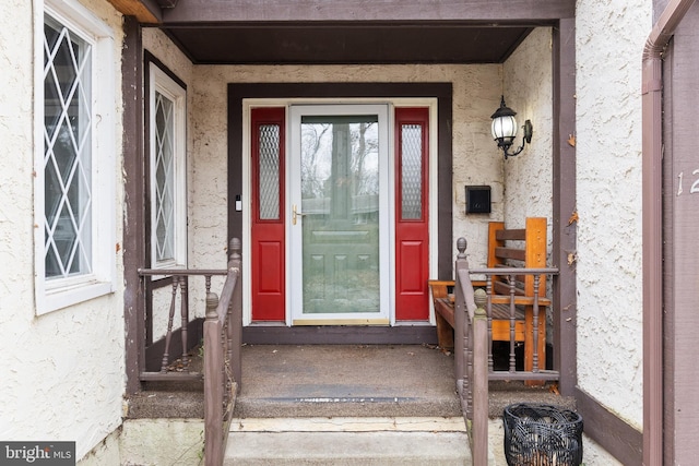 doorway to property featuring stucco siding