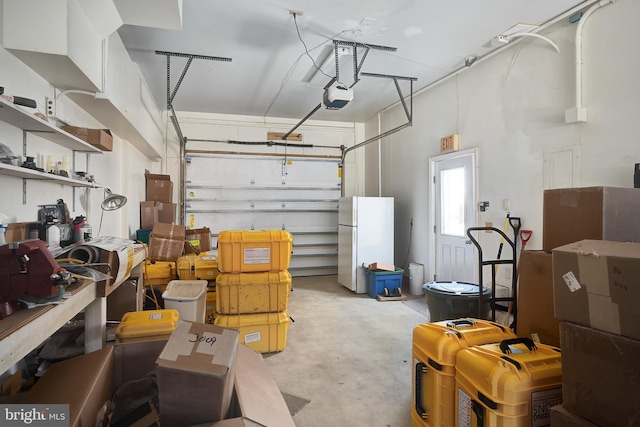 garage with a garage door opener and freestanding refrigerator