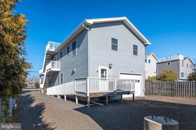 rear view of house with a garage and fence