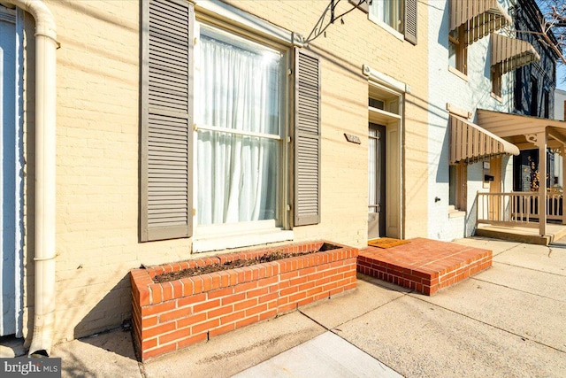 view of exterior entry with brick siding