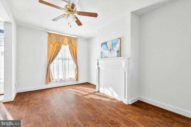 empty room featuring wood finished floors, a ceiling fan, and baseboards