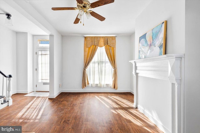 foyer with plenty of natural light, stairs, baseboards, and wood finished floors