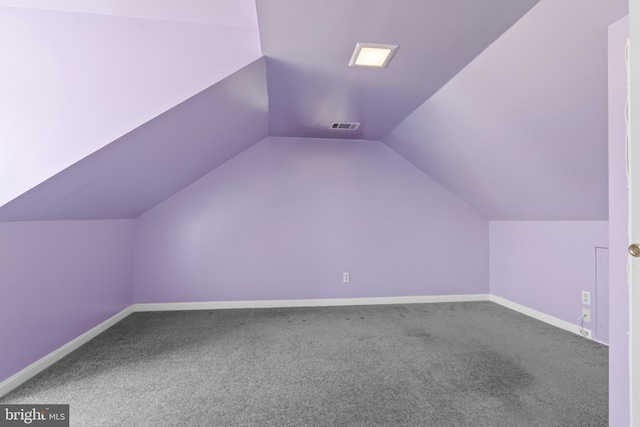 additional living space featuring carpet, vaulted ceiling, baseboards, and visible vents