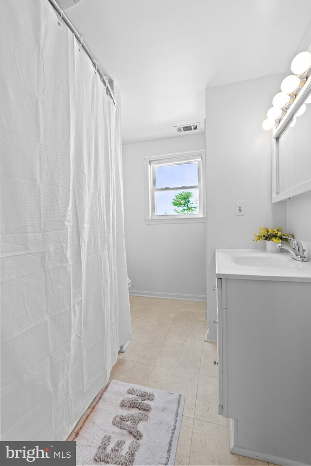 bathroom featuring vanity, a shower with shower curtain, baseboards, and visible vents