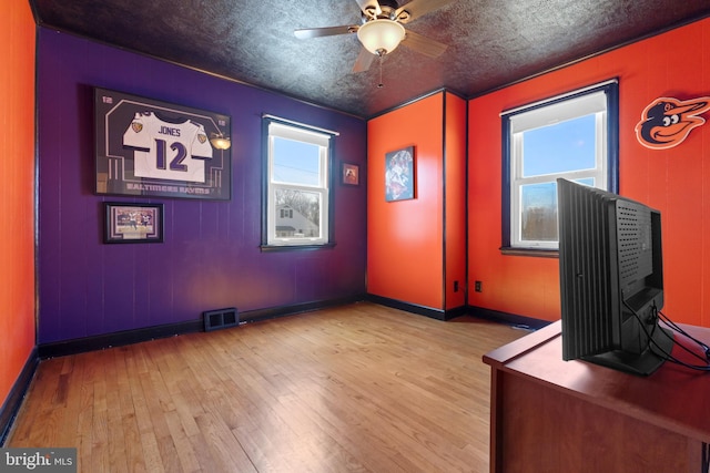 interior space featuring visible vents, wood-type flooring, and a textured ceiling