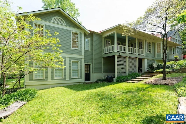 rear view of property featuring a yard and a balcony