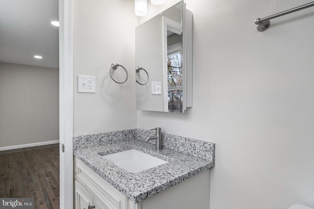 bathroom featuring vanity, baseboards, and wood finished floors