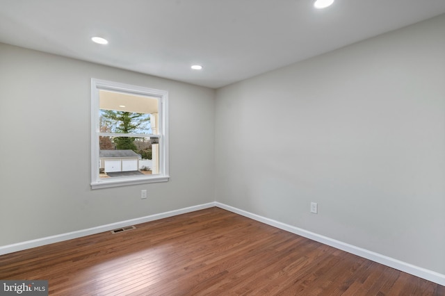 empty room with recessed lighting, visible vents, baseboards, and wood finished floors