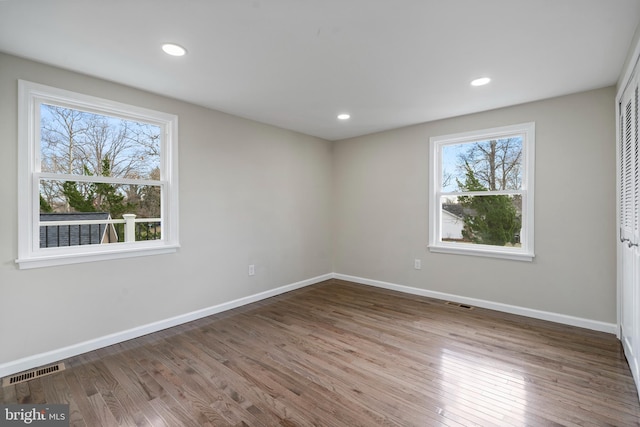 unfurnished bedroom featuring recessed lighting, wood finished floors, visible vents, and baseboards