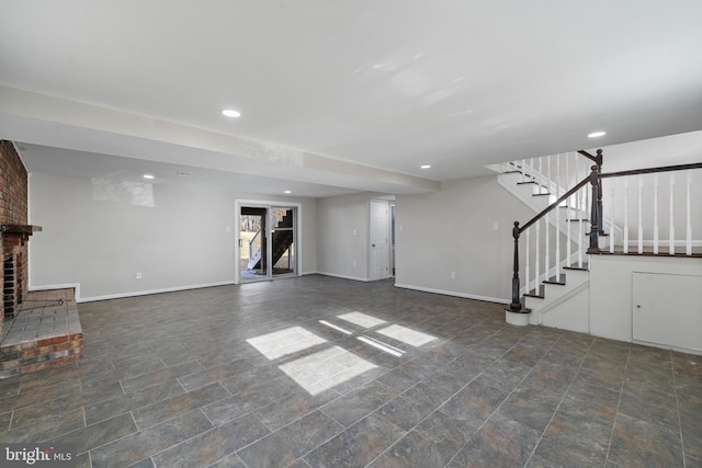 unfurnished living room with stairs, recessed lighting, a brick fireplace, and baseboards