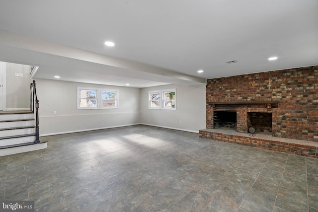 unfurnished living room with recessed lighting, stairway, a brick fireplace, and baseboards