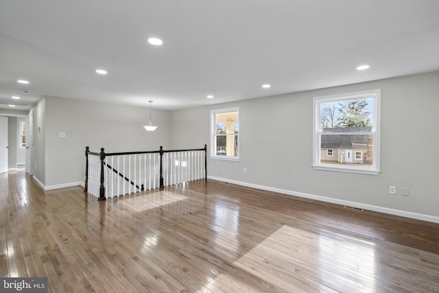 unfurnished room with visible vents, baseboards, wood finished floors, and recessed lighting