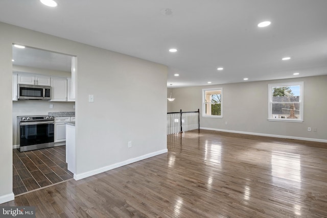 interior space featuring dark wood-style floors, recessed lighting, and baseboards