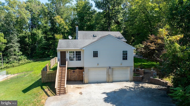 view of front of property with an attached garage, fence, driveway, a front lawn, and stairs