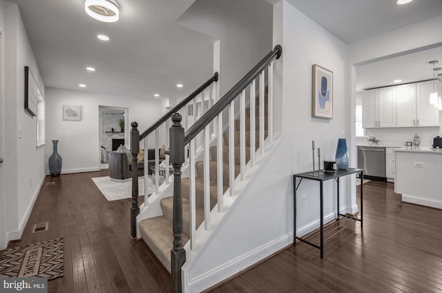 stairs with baseboards, visible vents, wood finished floors, and recessed lighting