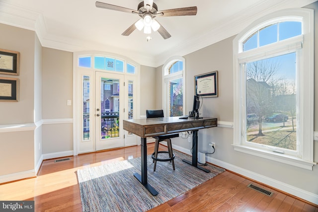 office featuring ornamental molding, light wood-style flooring, visible vents, and baseboards