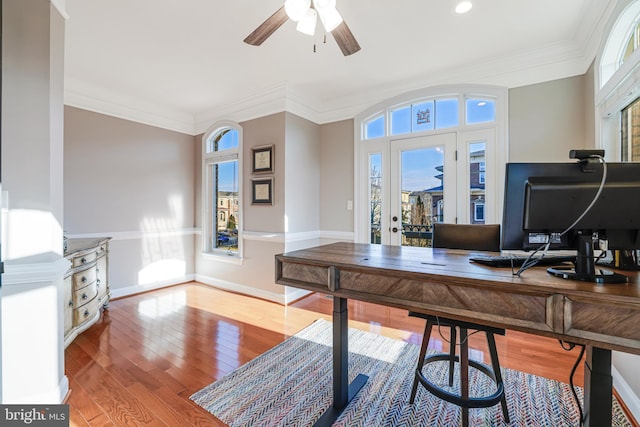 office space featuring ceiling fan, crown molding, baseboards, and wood finished floors