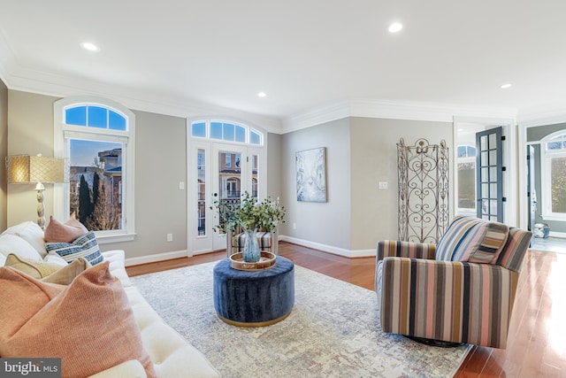 living area with ornamental molding, light wood-type flooring, french doors, and baseboards