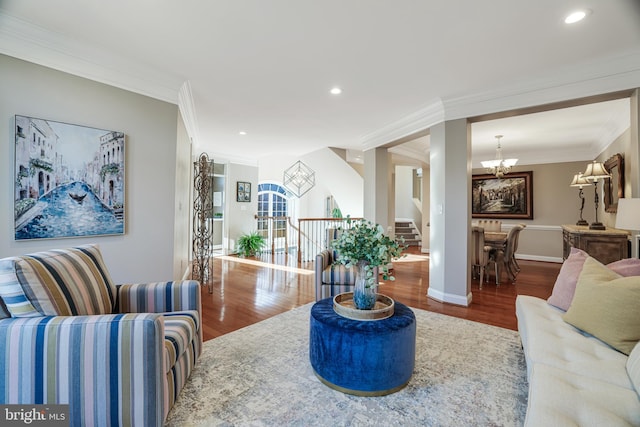 living room with baseboards, a chandelier, wood finished floors, and ornamental molding