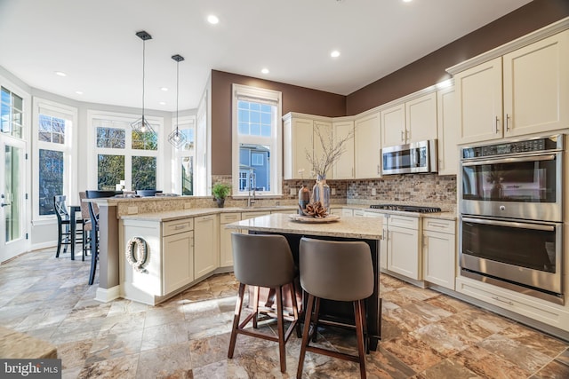 kitchen featuring stainless steel appliances, a center island, and a breakfast bar area