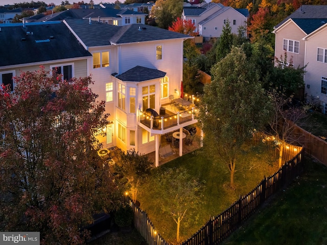 rear view of property with a balcony, a fenced backyard, and a residential view