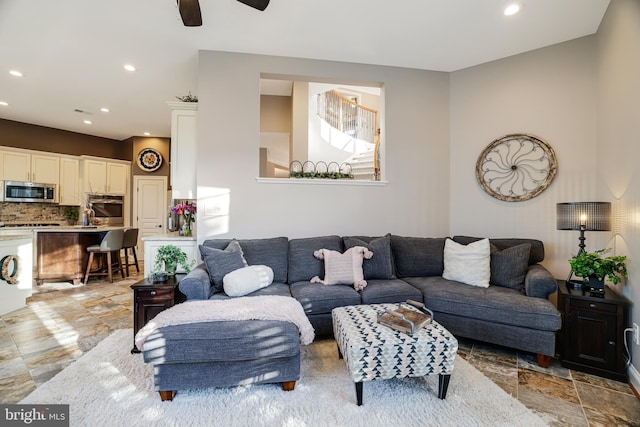 living area with ceiling fan, stone finish flooring, and recessed lighting