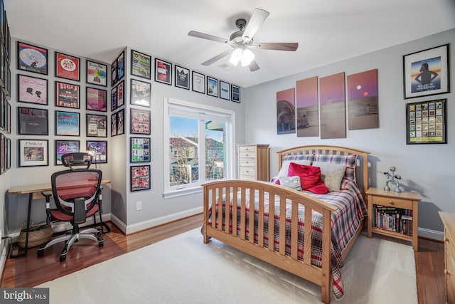 bedroom featuring ceiling fan, wood finished floors, and baseboards