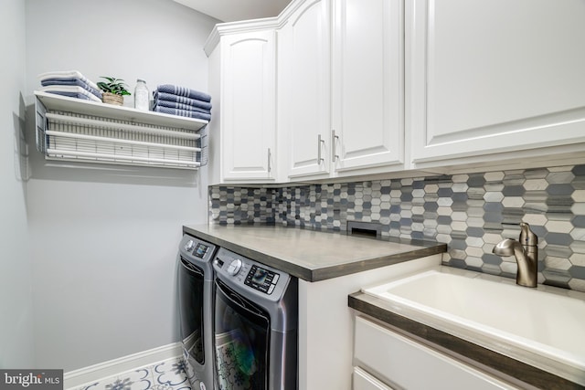 laundry room with washing machine and dryer, a sink, cabinet space, and baseboards