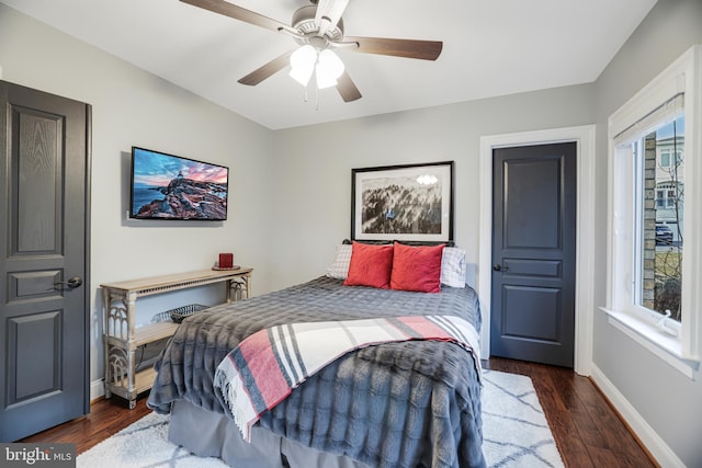 bedroom with dark wood-type flooring, baseboards, and a ceiling fan