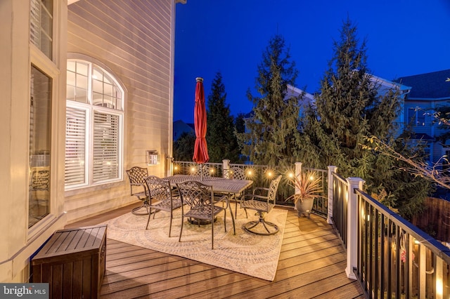 deck at twilight featuring outdoor dining area