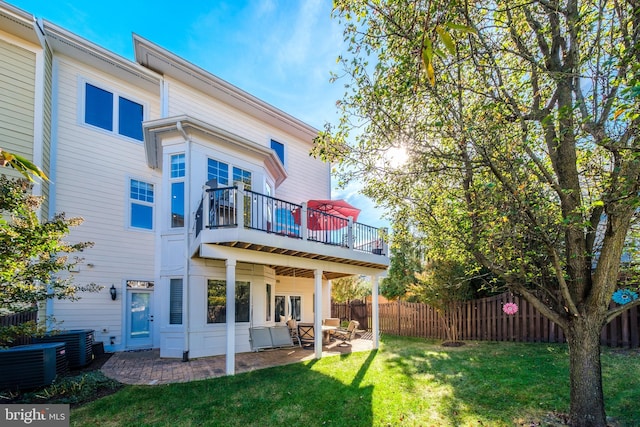 rear view of house with central AC, a patio, a lawn, and fence