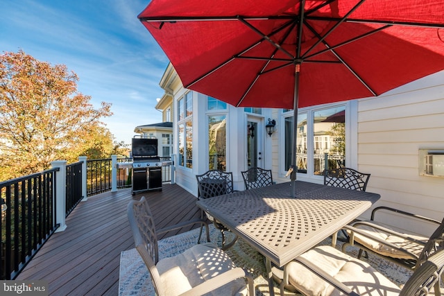 wooden deck featuring a grill and outdoor dining space