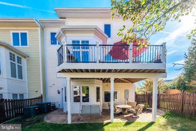 back of property featuring a patio, a fenced backyard, and a balcony