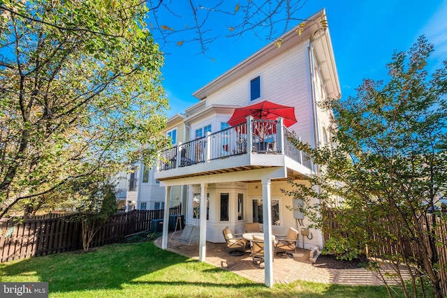 back of property with a fenced backyard, a lawn, and a patio