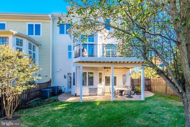 rear view of house featuring a yard, a fenced backyard, and a patio