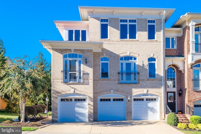 view of front of house featuring driveway, a garage, and brick siding