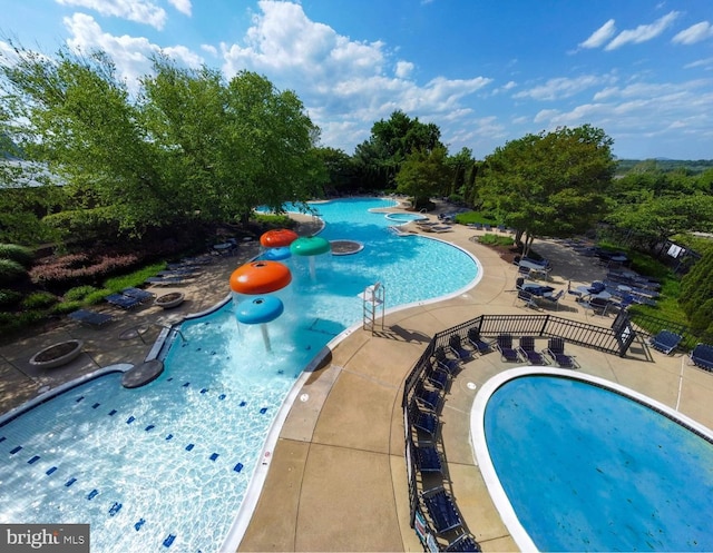 pool with a patio and a water play area