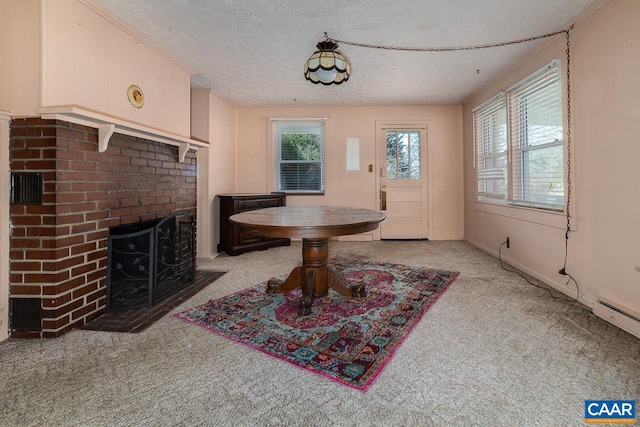 carpeted dining room with a brick fireplace, baseboard heating, and a textured ceiling