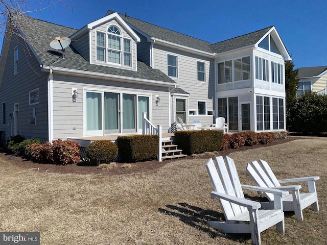 back of property featuring roof with shingles and a sunroom