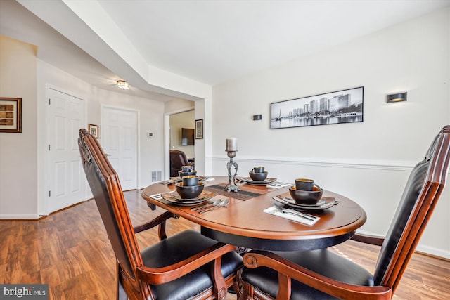 dining room featuring wood finished floors, visible vents, and baseboards